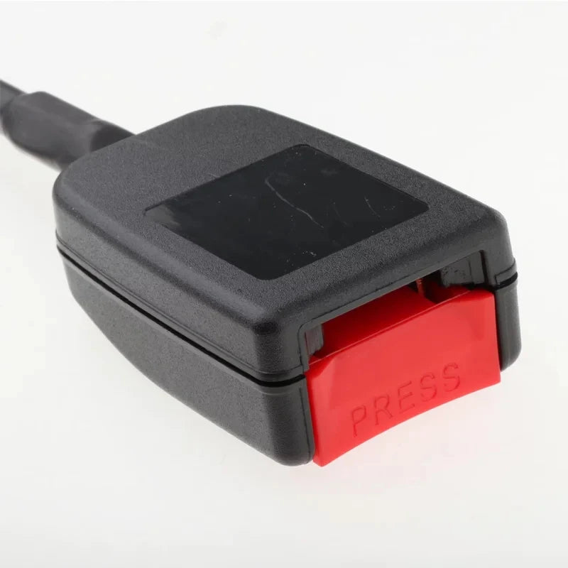 Close-up of the black plastic housing and red press release button on a flexible wire seat belt buckle receiver