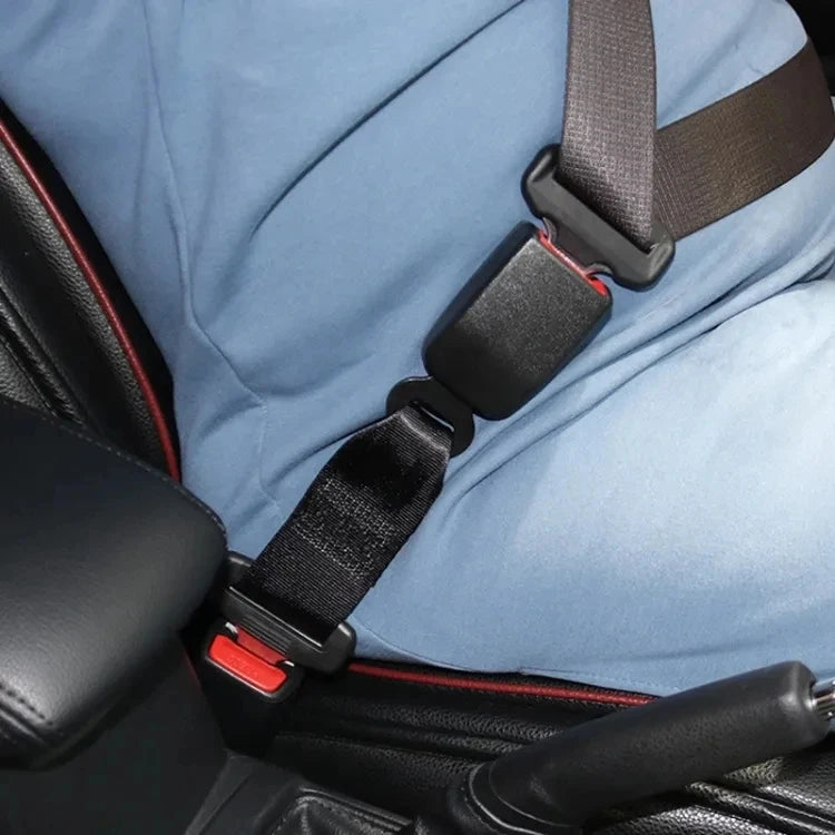 Black 32cm seat belt extender clipped into a car seat buckle and worn across a driver in a vehicle.