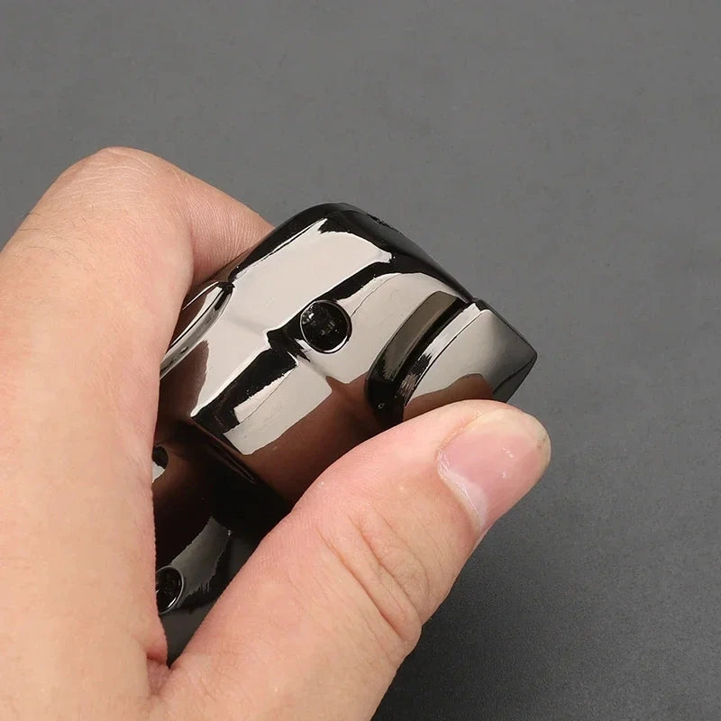Close-up of hand holding glossy black Nissan seat belt extender showing mirror plating detail