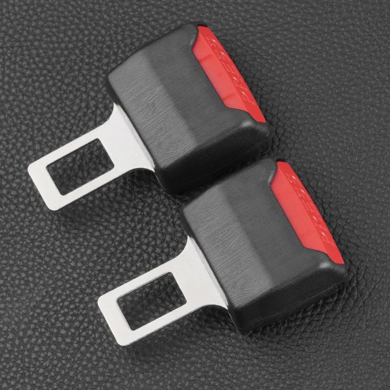 Two black and red seat belt buckles on a textured gray background