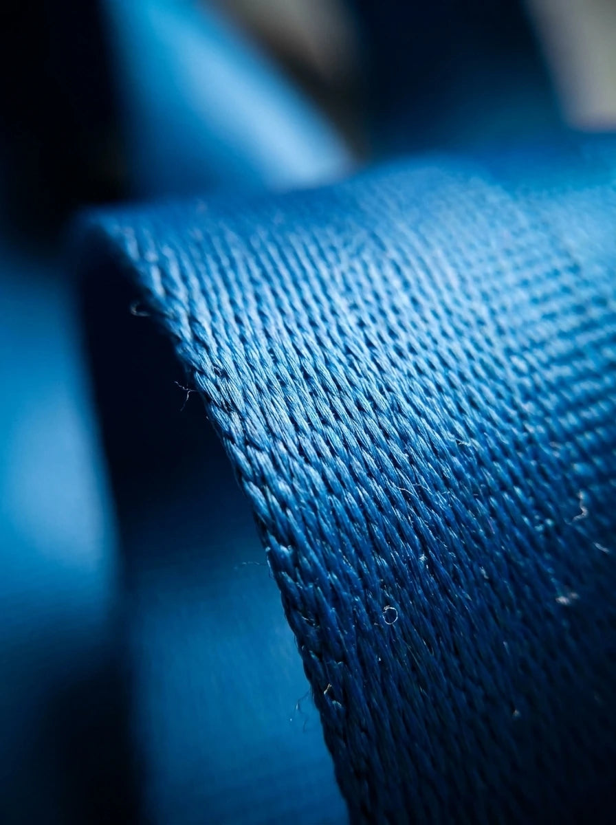 Extreme close-up macro shot showing the high-density blue nylon webbing weave and heavy-duty stitching of the Type B airplane seat belt extender