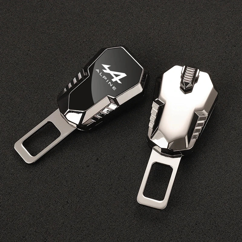 Front and back view of Alpine metal seat belt clip extender featuring white Alpine logo on dark metallic body