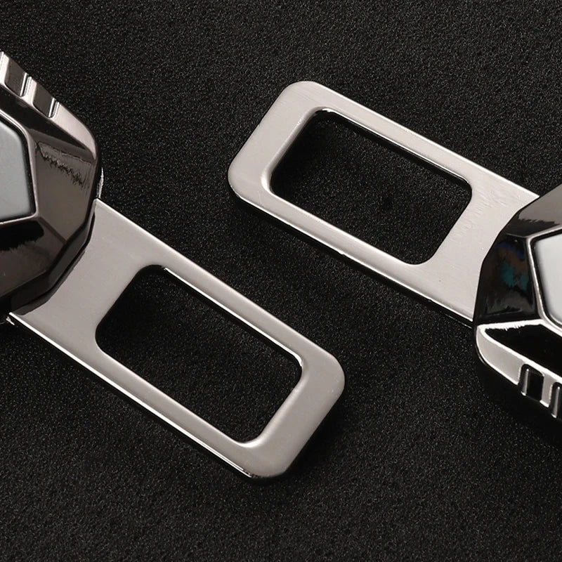 Close-up detail of metallic grey double buckle seat belt extender clip showing metal extension tongues on dark textured background